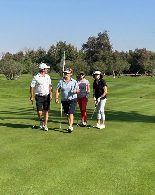 Groupe de golfeurs sur le green avec coach professionnel